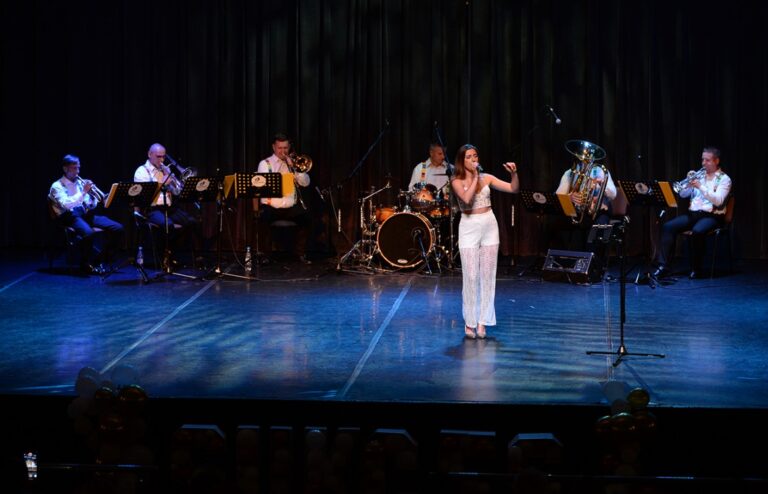 Wokalistka śpiewa z zespołem